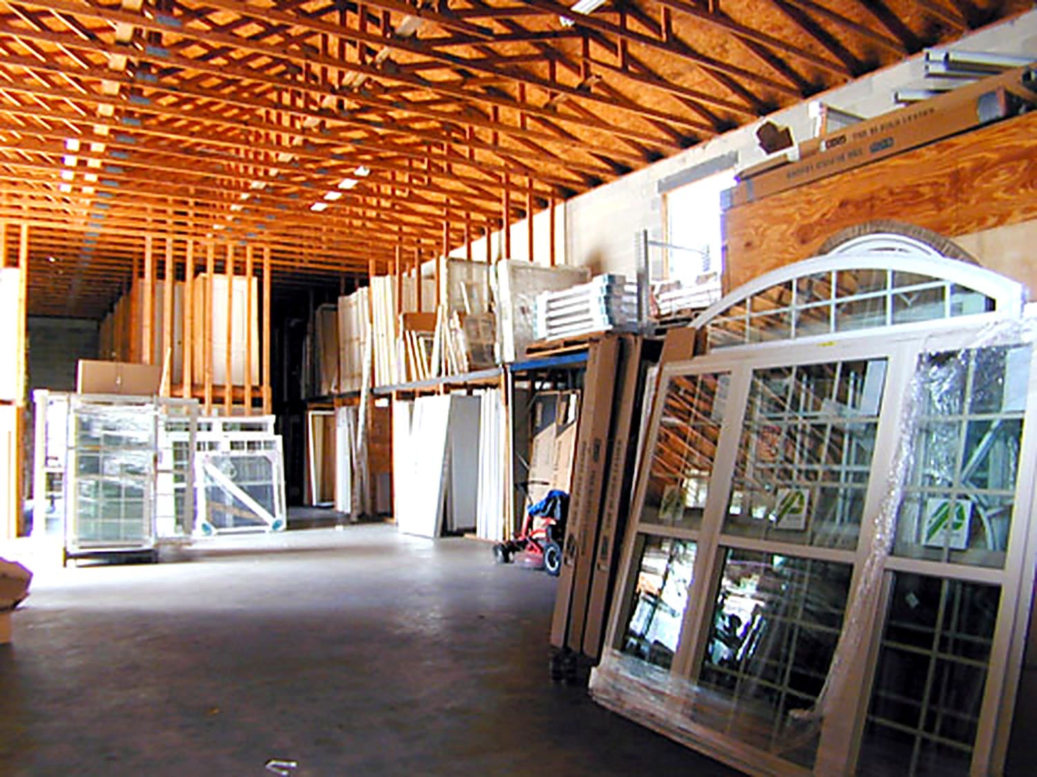 Inside the Coastal Hardware window and door warehouse with arched and rectangular windows lining the wall